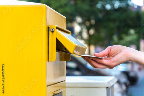 Throwing a letter in a yellow mailbox Fototapet