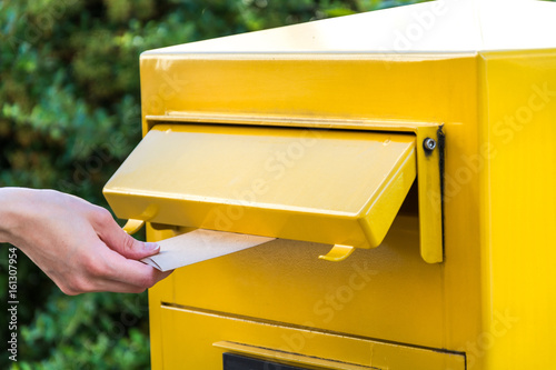 Throwing a letter in a yellow mailbox