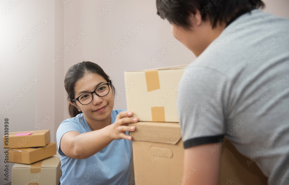 Young people checking cardboard boxes in their small warehouse. Own business. Young people checking cardboard boxes in their small warehouse. Own business.
