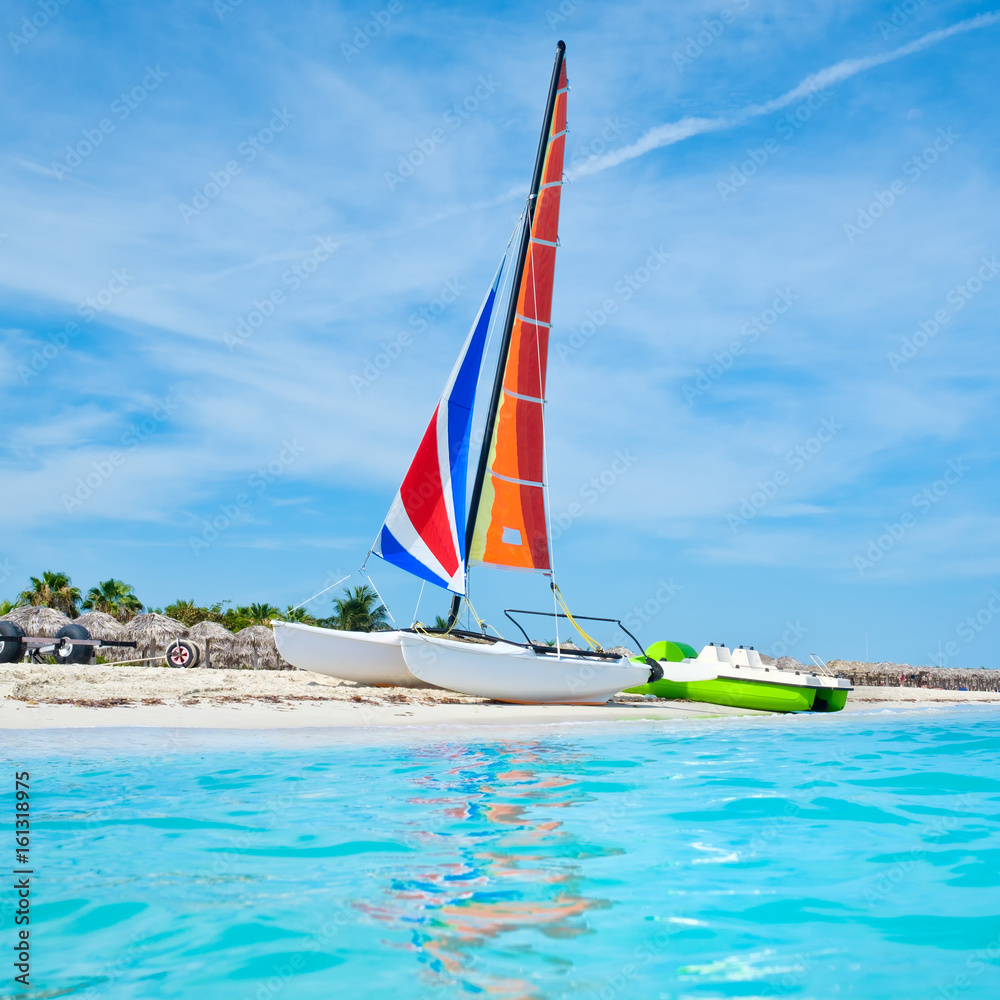 Naklejka premium The beautiful beach of Varadero in Cuba with a colorful sailboat
