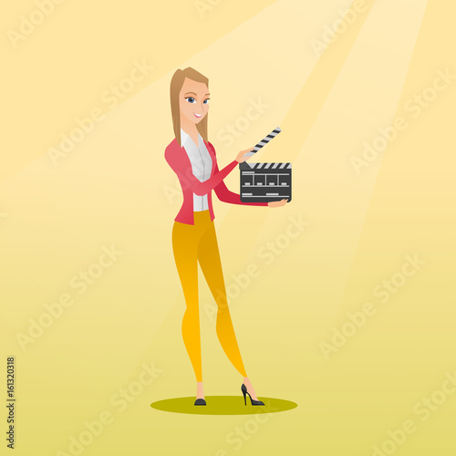 Smiling woman holding an open clapperboard.