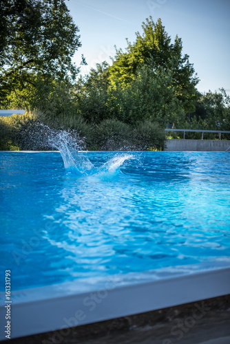 Water splash in swimming pool after jump in the water