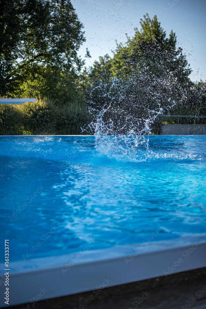 Water splash in swimming pool after jump in the water