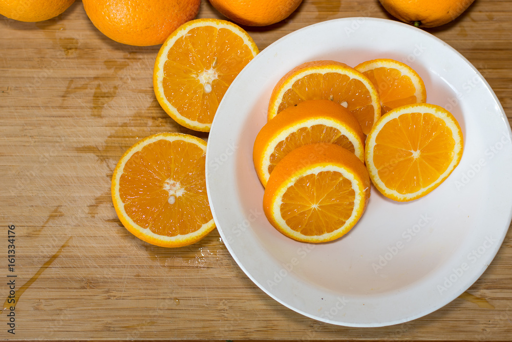 Oranges on a table and on a white plate Oranges on a table and on a white plate