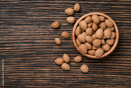 almonds nuts on a brown wooden table,top view