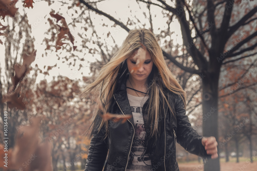 Young blonde woman enjoying autumn and fallen leaves Young blonde woman enjoying autumn and fallen leaves