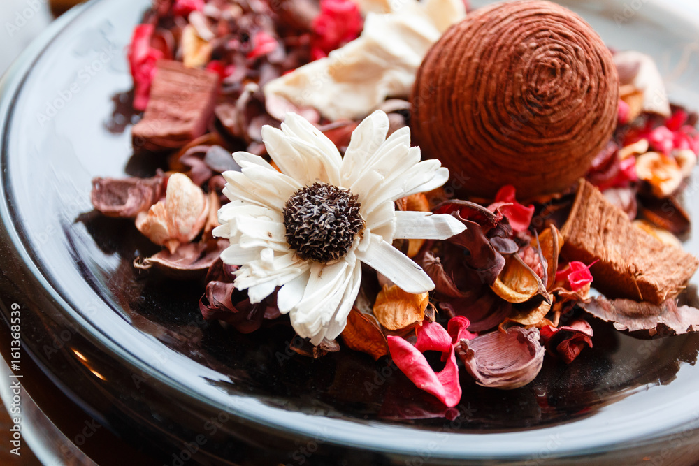 Plate with wicker balls. Decorative object asian wooden wicker spheres lay in wooden bowl with decorative elements of flowers