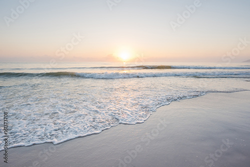 Beautiful sunset and gentle wave at the shallow beach
