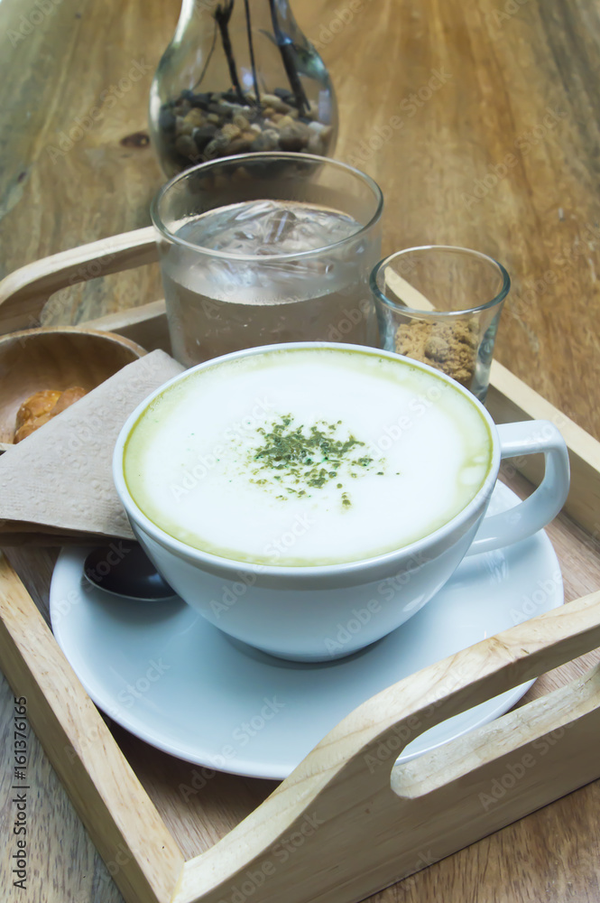 Hot green tea latte with matcha powder on wooden background. Hot green tea latte with matcha powder on wooden background.