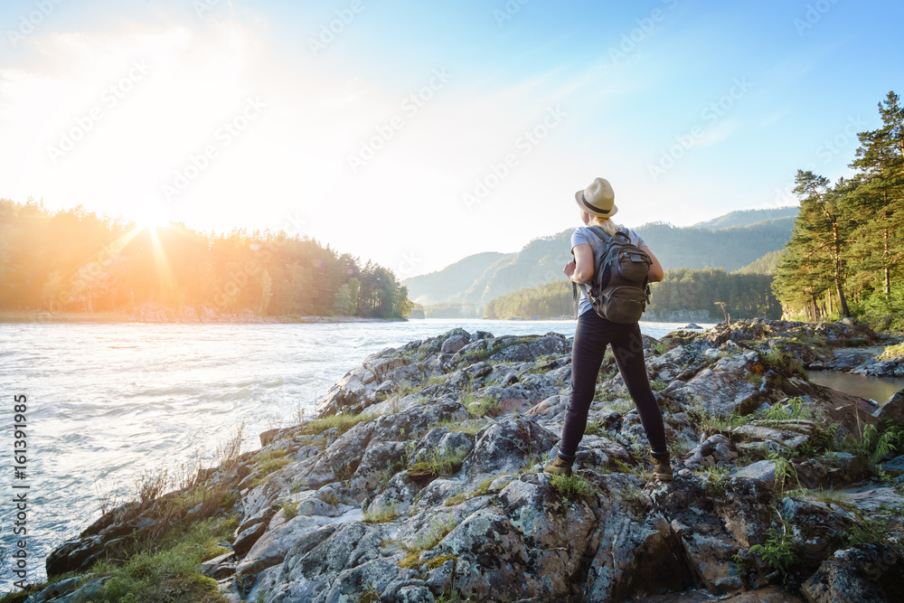 Young woman walking along the in the National Park. To dream of looking at the river.