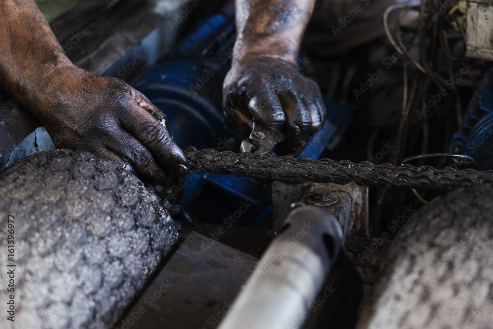 Hand during maintenance work of chain Hand during maintenance work of chain