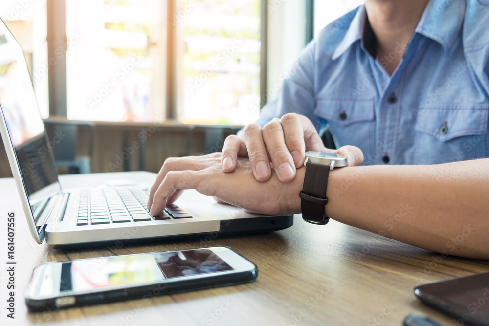Fototapeta premium Business man pointing his watch with his finger at office