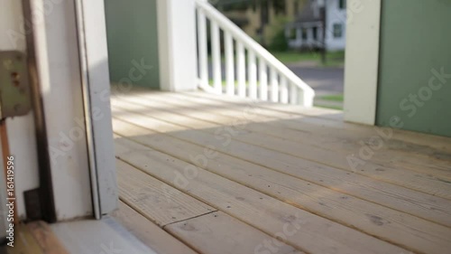 A female picks up a package from outside his front door