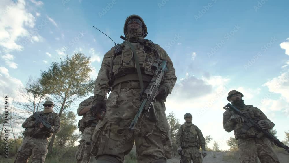 Military people standing in nature and looking around.