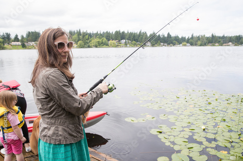 Woman lake fishing on a dock