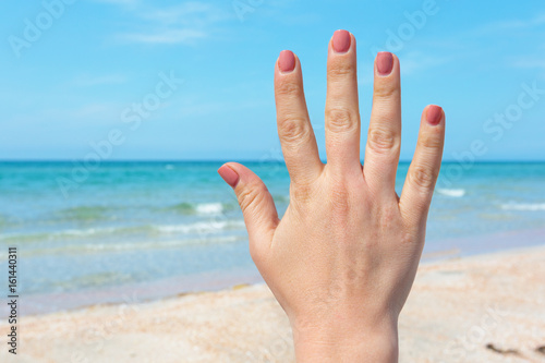 hand sign over blue sea and sky background, summer travel, holiday vacation concept background