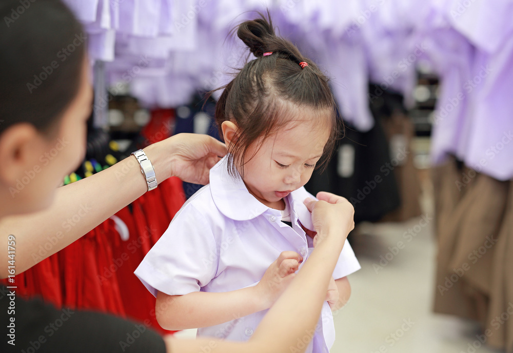 Mother try dressing school uniform for her daughter, Kindergarten ...