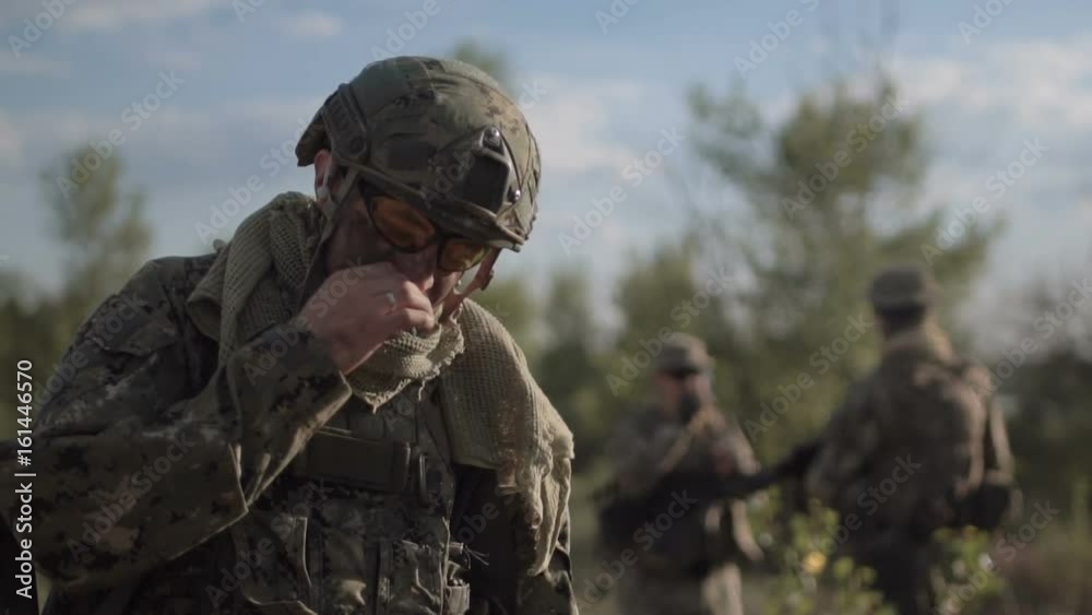 Slow motion, soldier on battlefield having a smoke while other soldiers talking at background Slow motion, soldier on battlefield having a smoke while other soldiers talking at background