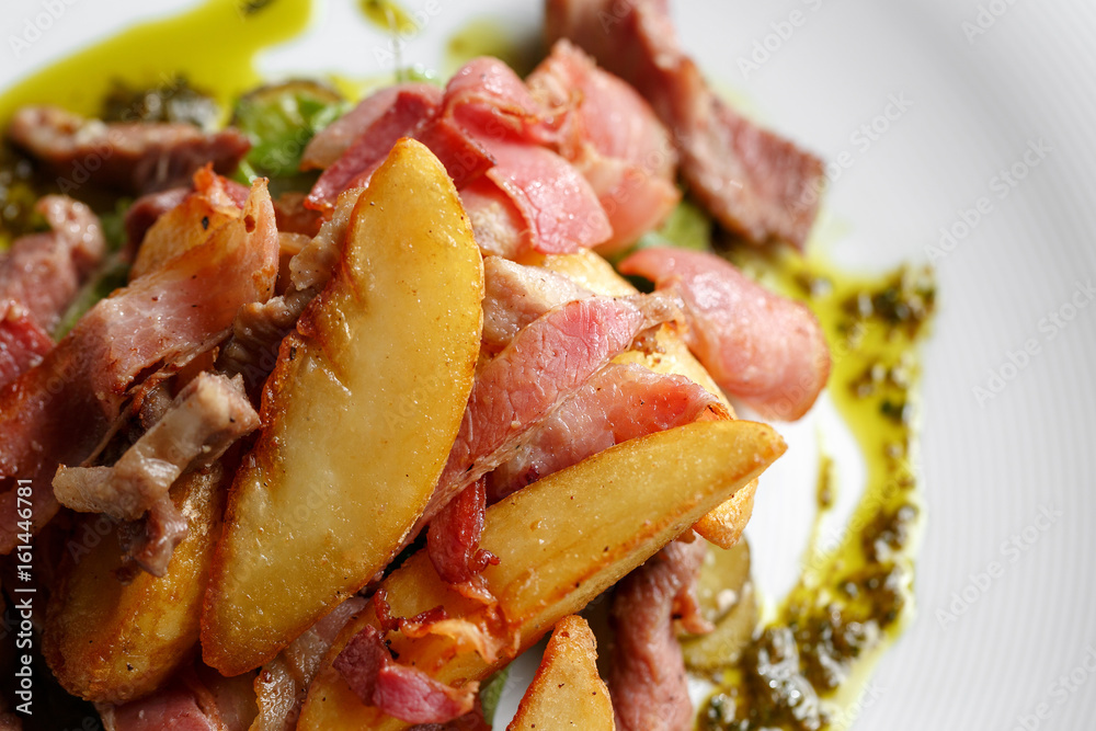 Fried potato with bacon and green beans on plate over wooden background. Fried potato with bacon and green beans on plate over wooden background.