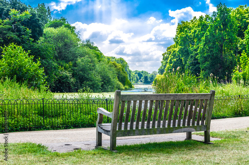 Fototapeta Naklejka Na Ścianę i Meble -  Wooden bench at St James's Park on a summer day, London