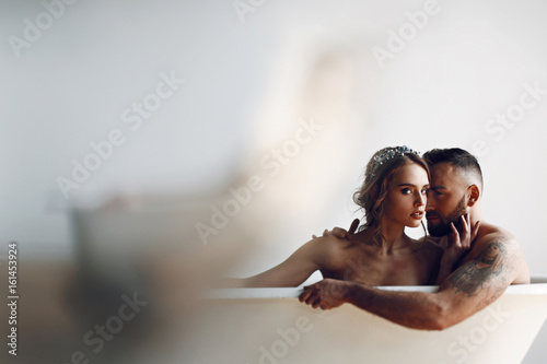 Man kisses woman tender while they rest in the bath