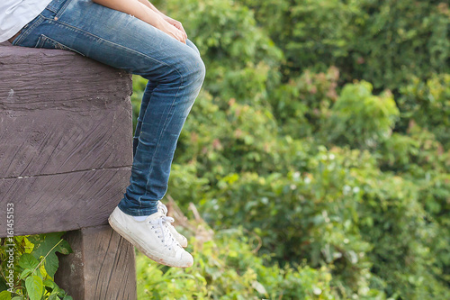 people sit on wooden seat and dangle  legs