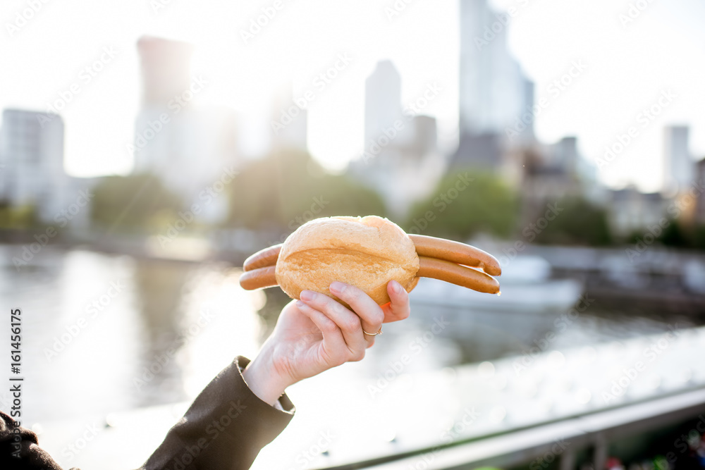 Φωτογραφία Traditional frankfurt sausages with bread in the hand on the Frankfurt city back