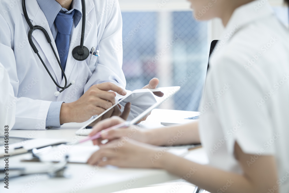Doctors and nurses are meeting while watching the tablet Doctors and nurses are meeting while watching the tablet