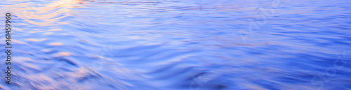 Light reflection on blue river wave ripples surface. Abstract, tranquility,romance.