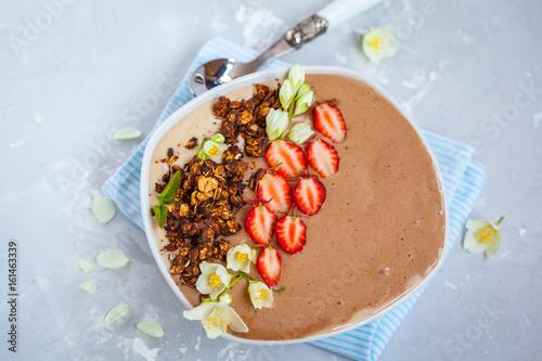 Chocolate smoothie bowl with strawberries and chocolate granola. Love for a healthy vegan food concept