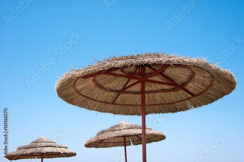 Cane wicker beach umbrellas close against the sky in Sunny weather.