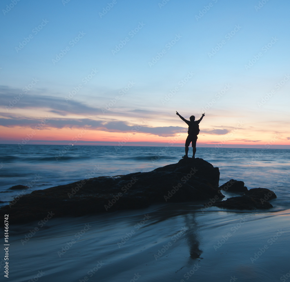 silhouette of man standing enjoying on a stone tropical sunset silhouette of man standing enjoying on a stone tropical sunset
