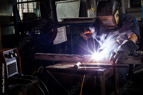 Welder working a welding metal with protective mask and sparks