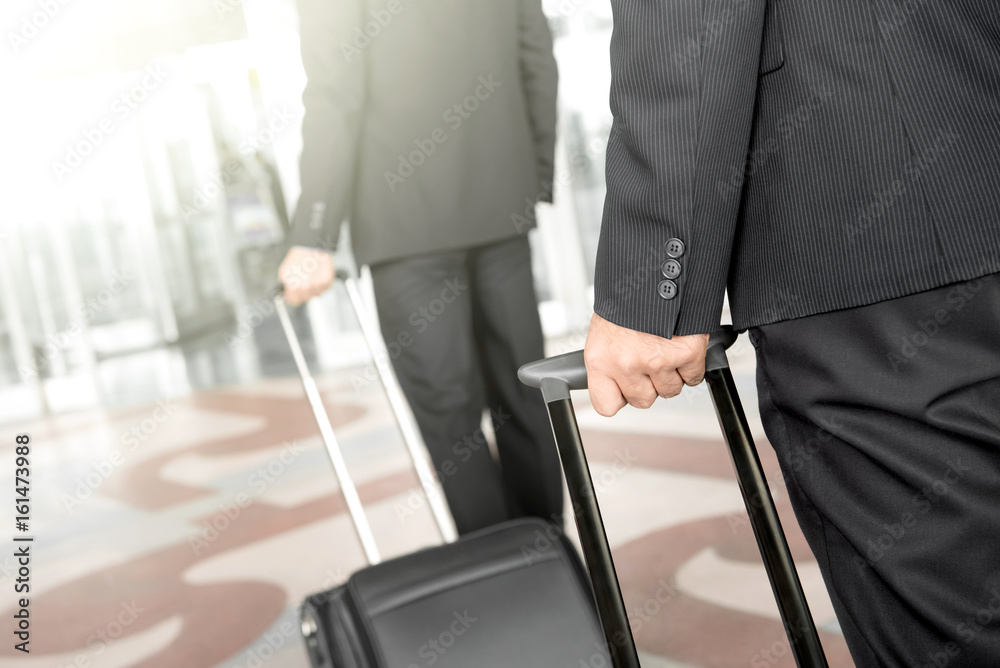 Businessmen pulling baggage while walking at the airport Businessmen pulling baggage while walking at the airport