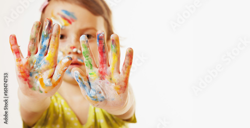 Colorful painted hands in a beautiful young girl (art, childhood, colour concept)