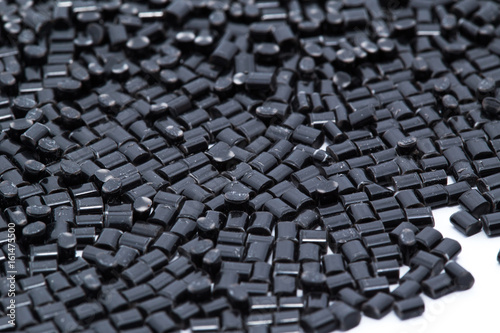 Black plastic polymer granules on white background