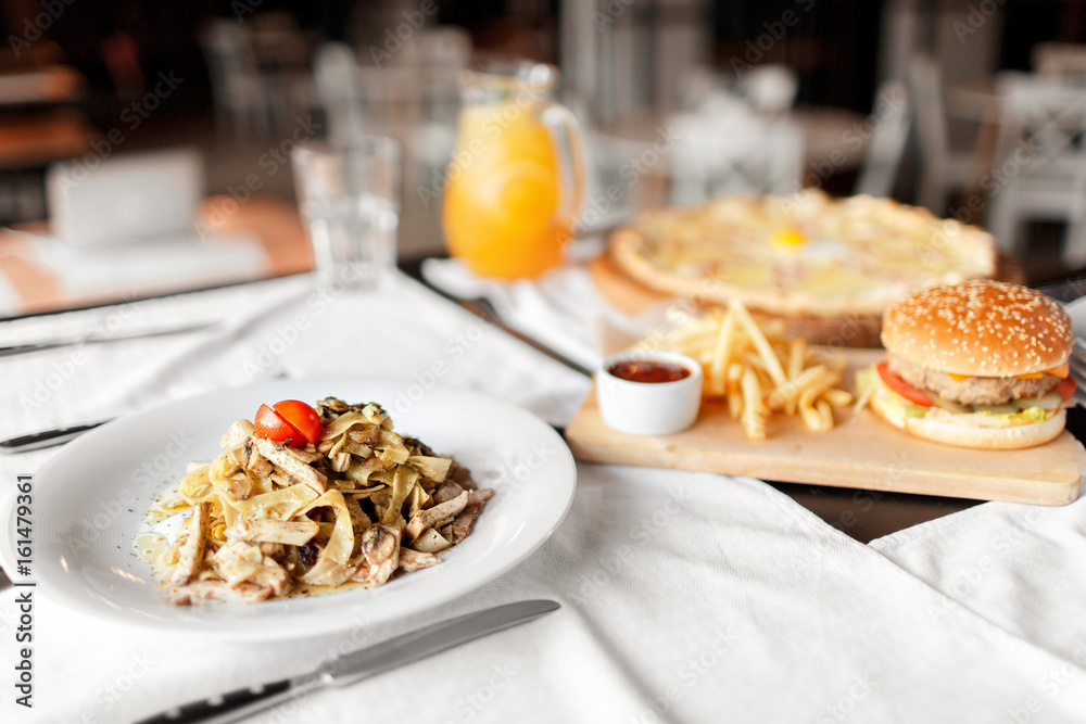 beautiful table of italian pasta, pizza, burger and drinks. selective focus beautiful table of italian pasta, pizza, burger and drinks. selective focus