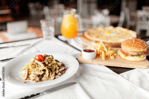 beautiful table of italian pasta, pizza, burger and drinks. selective focus