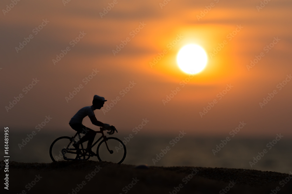 Silhouettes model of cyclists on the beach with sunset.