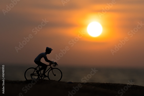 Silhouettes model of cyclists on the beach with sunset.