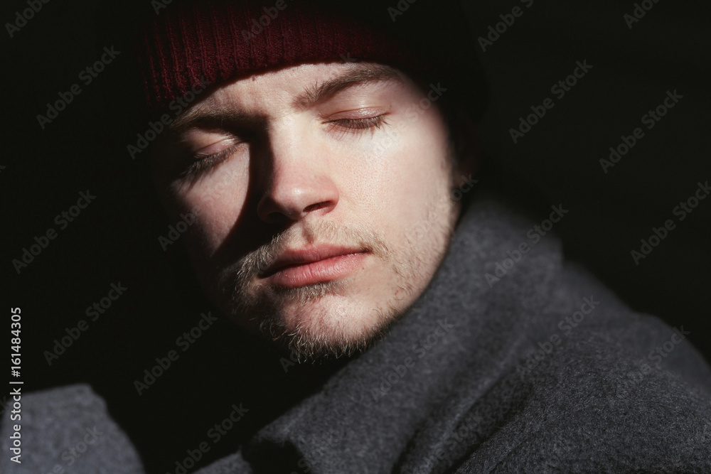 Young bearded man enjoys the sun in red hat Young bearded man enjoys the sun in red hat