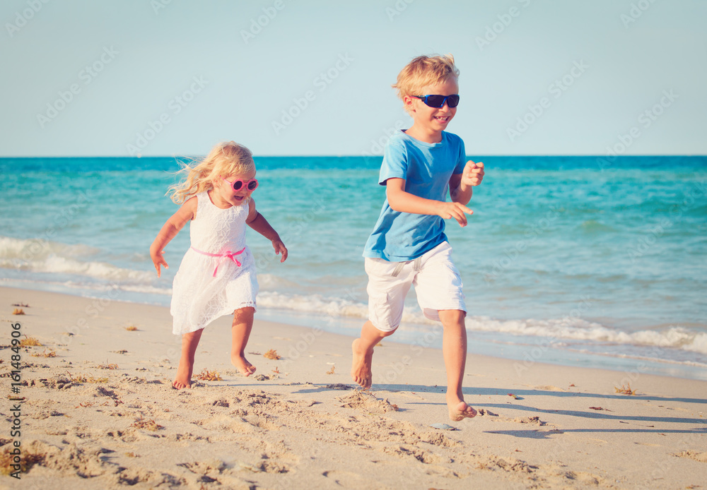little boy and girl running on beach