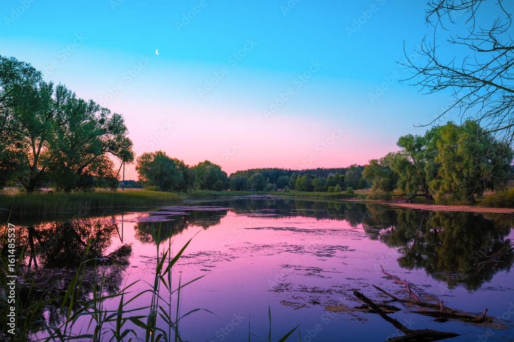 Magical pink purple sunrise over the lake. Misty morning, rural landscape, wilderness, mystical feeling