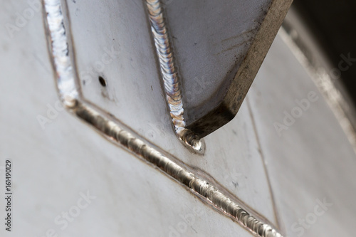 Stained steel plate with weld seam, industrial background texture