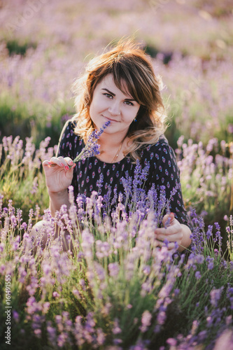 Young beautiful woman posing in a lavender field. Summer mood
