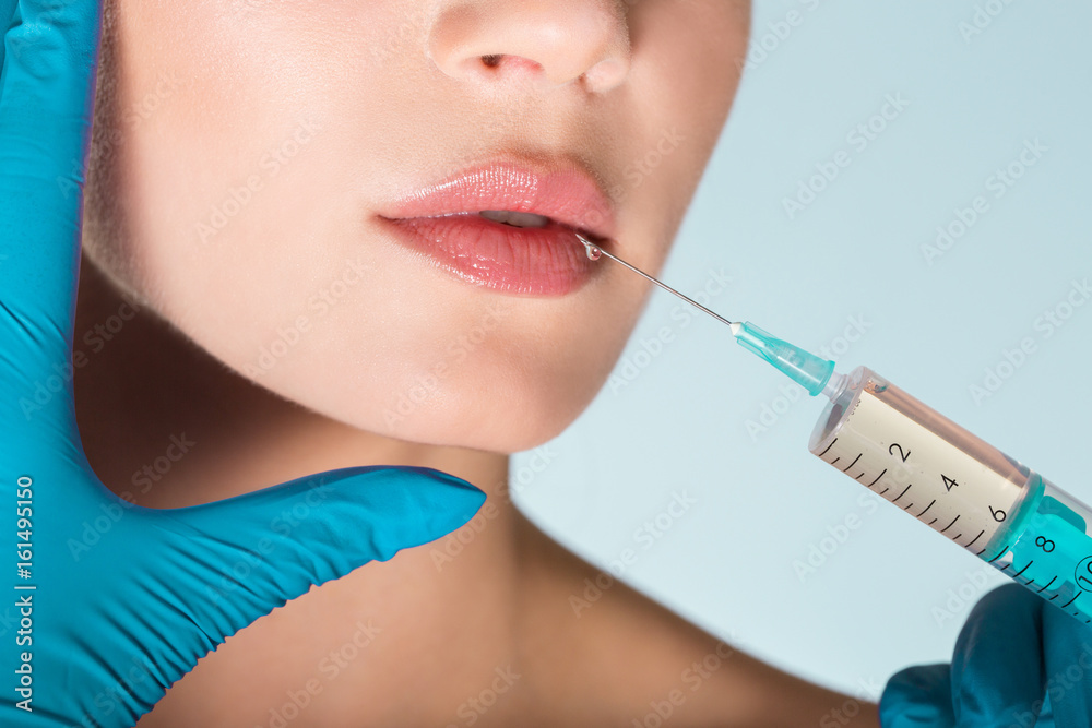 Cropped portrait of woman getting lips injection Cropped portrait of woman getting lips injection