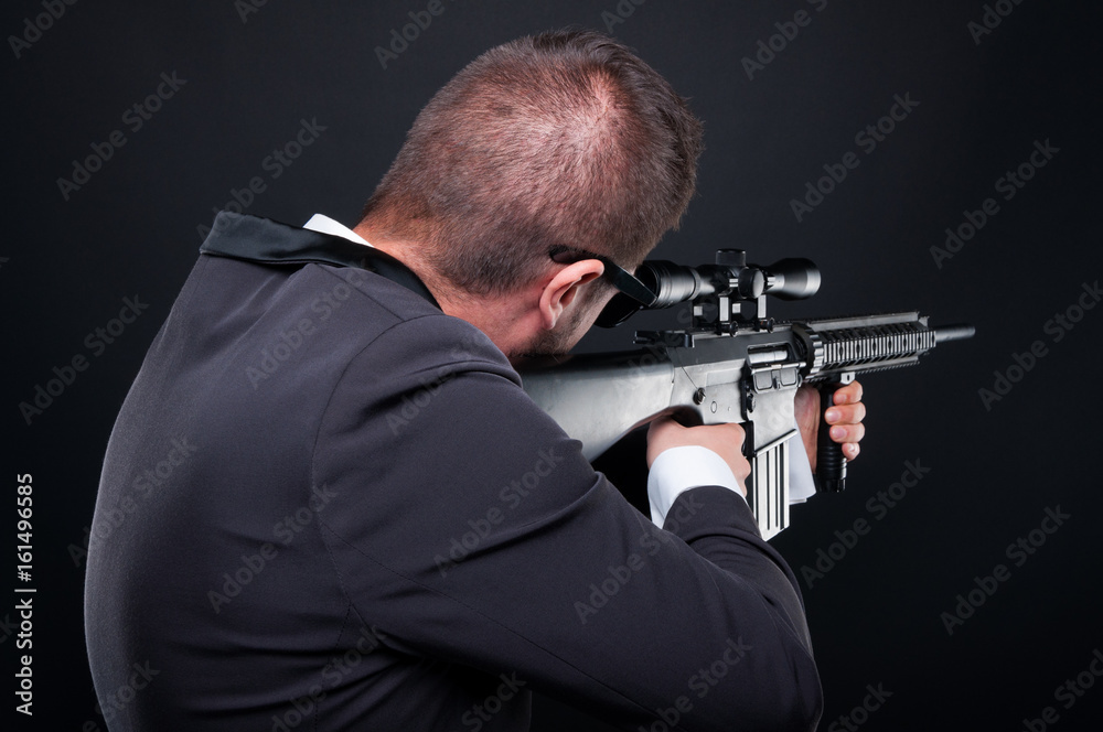 Back view of violent mafia member aiming rifle Back view of violent mafia member aiming rifle