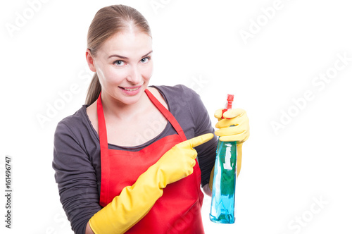 Pretty smiling housekeeper with cleaning spray