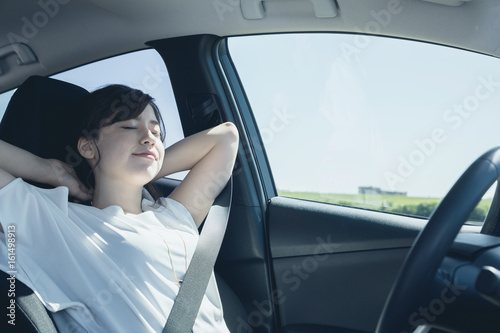 Obraz na plátně young woman sleeping on drivers seat of vehicle.
