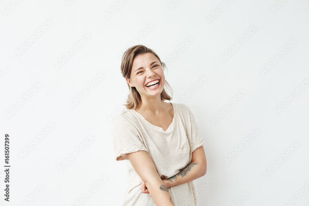 Fototapeta premium Cheerful happy young beautiful girl looking at camera smiling laughing over white background.